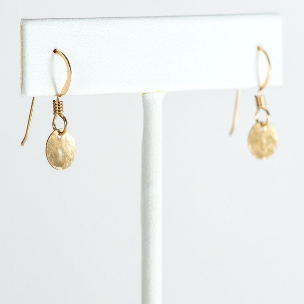 Gold mini disc earrings on T stand.