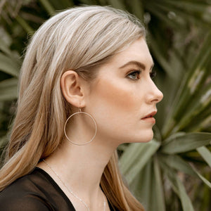 Large hoop earrings on blonde model.