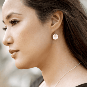 Small gold disc on larger silver disc earrings on model.