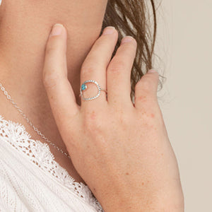 Hand closeup wearing a Cushion Frame Ring textured with Turquoise.