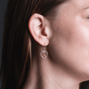 Heart enamel circle red earrings on silver on model.