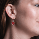 Heart enamel solid red earrings on model.