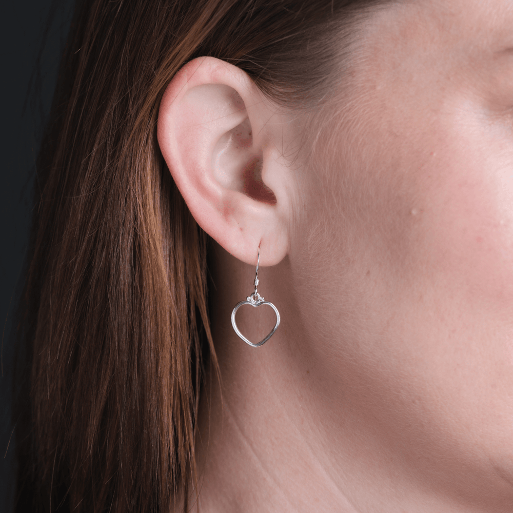 Heart plain earrings in silver on model.