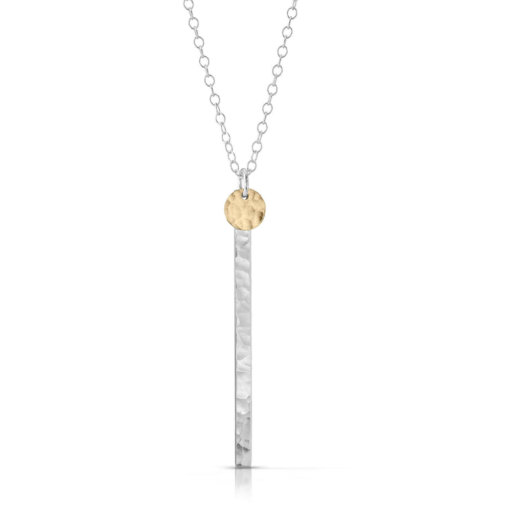 Small textured gold disc on silver skinny bar necklace.