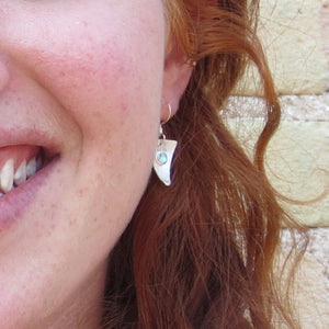 
                
                    Load image into Gallery viewer, Topaz triangle earrings in silver on a model.
                
            